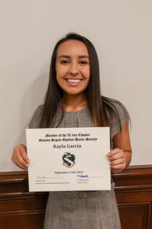Person holding a certificate and smiling indoors.