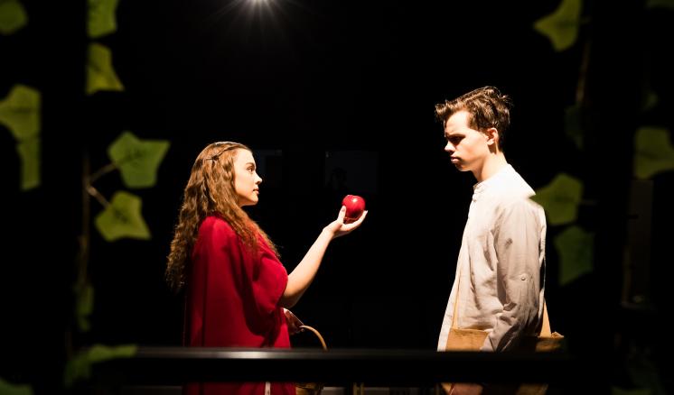 A man standing next to a woman holding an apple