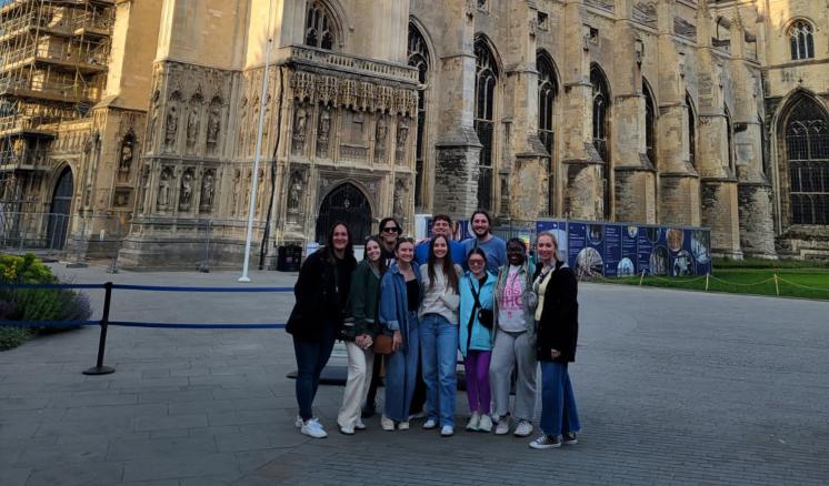A group of people outside in daylight standing in front of a cathedral