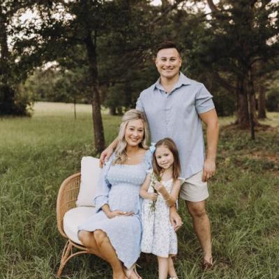 3 people sitting in a grassy field for a family photoshoot