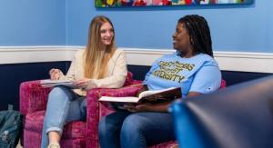 Two students sitting in a lobby chatting