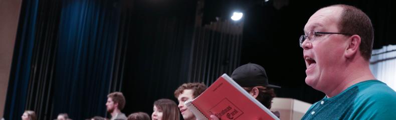 A group of people on a stage singing Christmas carols