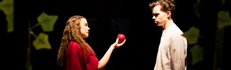 A man standing next to a woman holding an apple